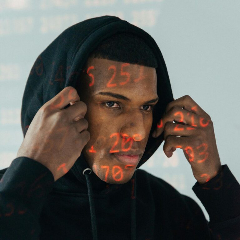 Homme avec des projections de chiffres numériques rouges sur le visage symbolisant la cybersécurité et le hacking éthique